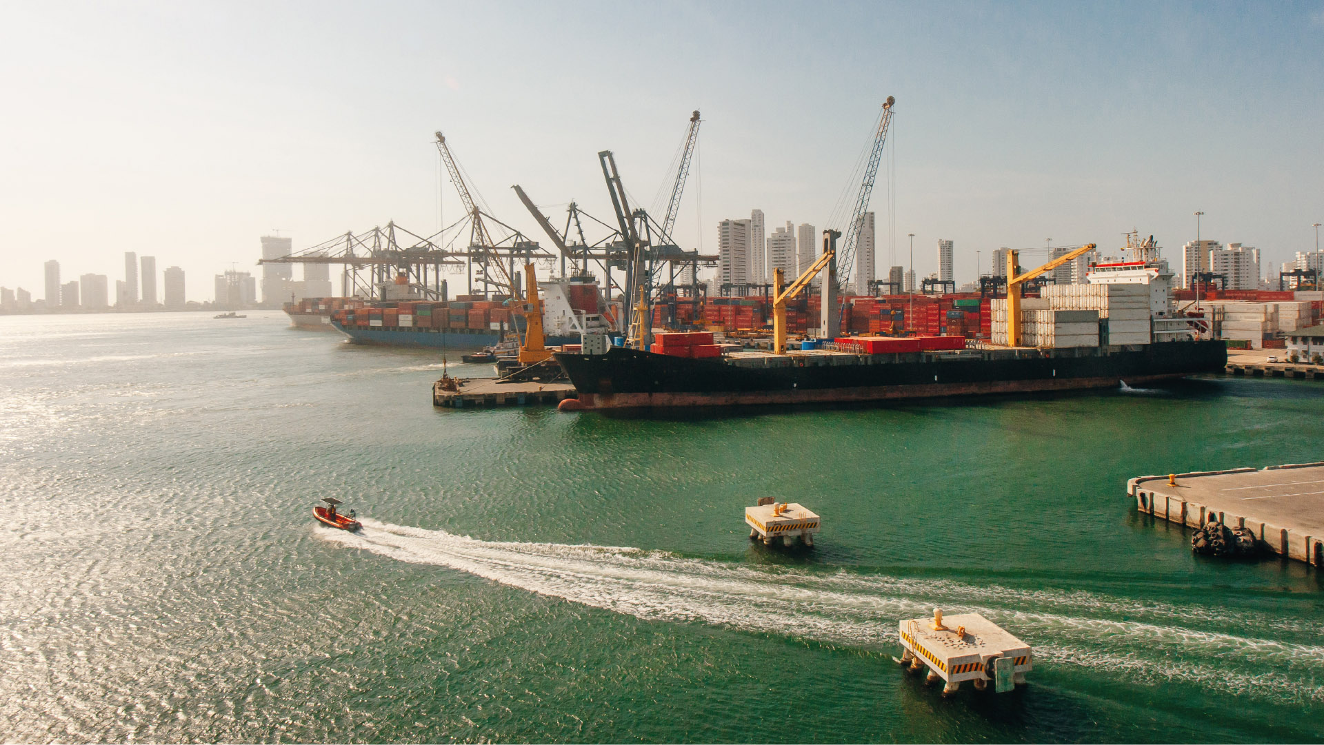 Port maritime avec des grues, des cargos et des conteneurs.