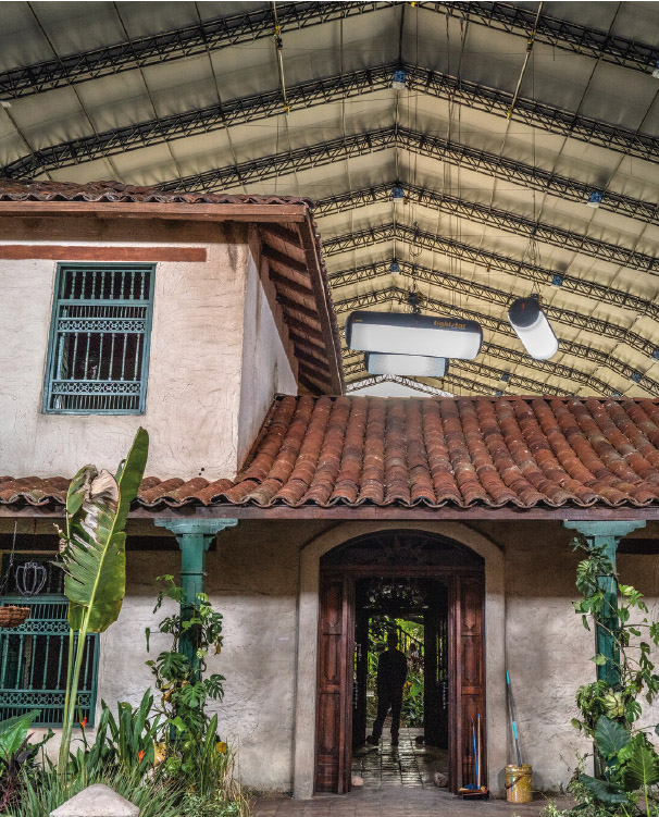 Colonial house with tile roof and person at the entrance.