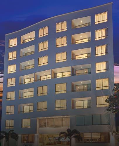 Facade of the Hotel Estelar Yopal with lights on at night.