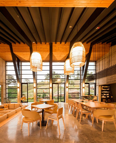 Warm interior of Casa Du Velo with wooden furniture and large windows.