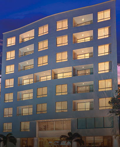 Fachada moderna del Hotel Estelar Yopal al anochecer, con luces encendidas en las ventanas.