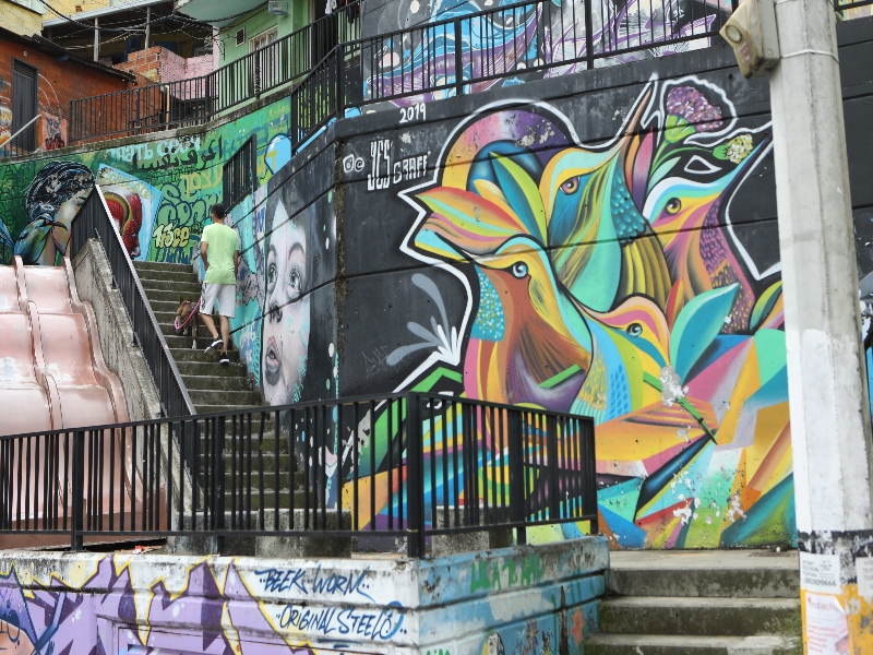 Grafiti de coloridos pájaros en una de las paredes de la Comuna 13 en Medellín, ideal para hacer turismo alternativo.