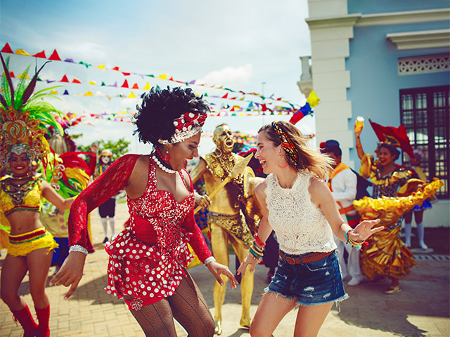 A tourist and a dancer enjoying the Barranquilla Carnival, one of Colombia’s most important carnivals.