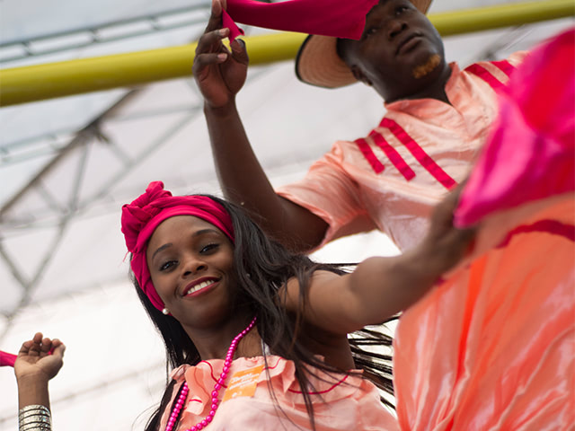 personajes disfrazados junto a turistas en el carnaval de blancos y negros planes turisticos colombia.