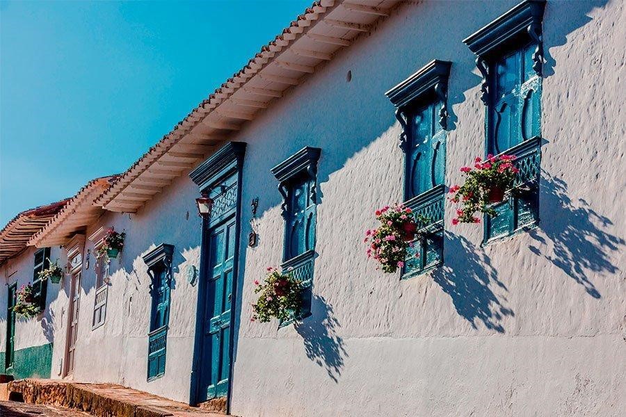 Colonial houses with pink flowers on the balcony