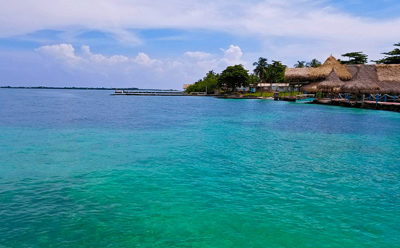 Crystal waters of the Caribbean Sea with the lodgins at Mucura Island as a background
