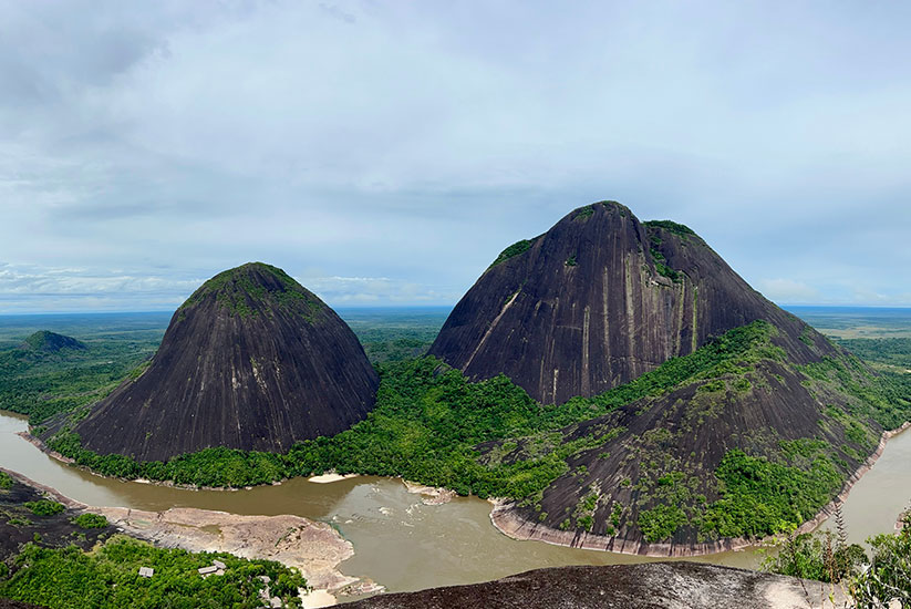 Rock formations of the Mavecure Hills surrounded by jungle and river