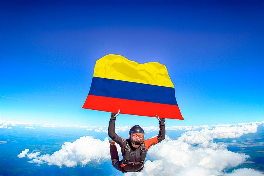 Parachutiste en chute libre tenant le drapeau de la Colombie