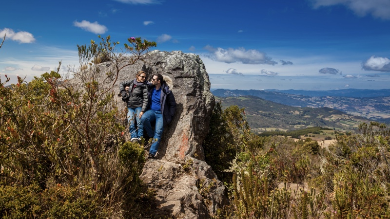 Una pareja se recuesta en una roca en medio de un paisaje. Una propuesta del turismo mindfulness.
