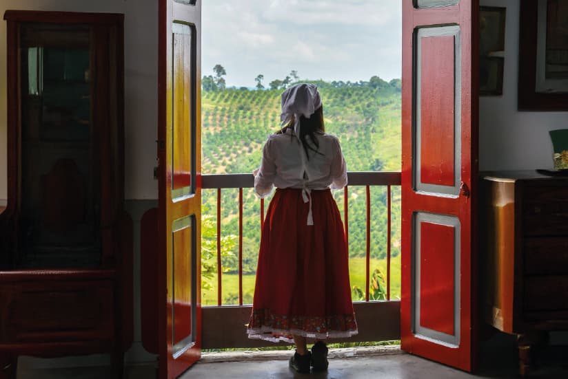 Mujer contemplando el paisaje cafetero en Colombia.
