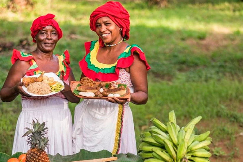 Palenquera women wearing traditional Colombian attire holding food