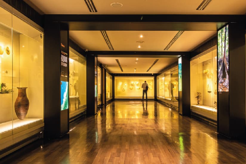 Interior del Museo del Oro en Bogotá con un visitante al fondo contemplando exposición