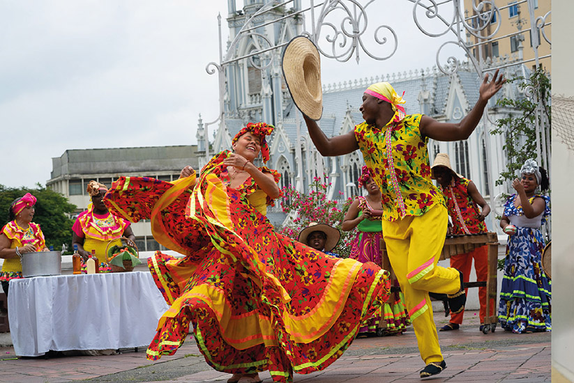 Pareja de bailarines con la Iglesia La Ermita de fondo, Cali, Colombia. 