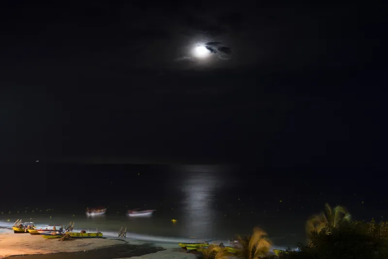 Vista panorámica de la ciudad de Santa Marta de noche con algunas embarcaciones en la playa