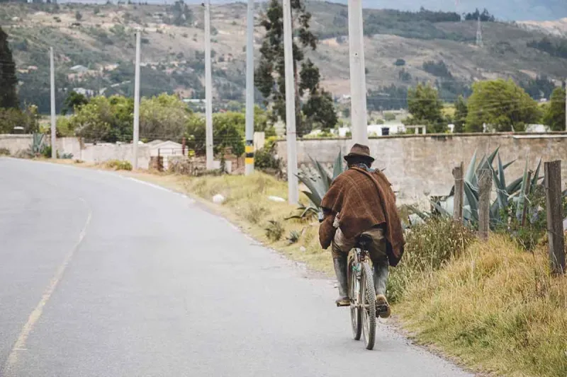 Campesino subiendo en bicicleta la loma de un pueblo cercano a Bogotá