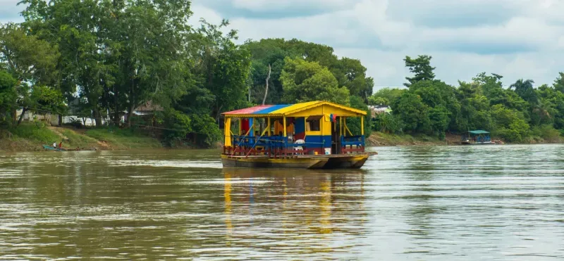 Ronda del Río Sinú en Montería, Colombia, rodeada de exuberante vegetación a lo largo del río.