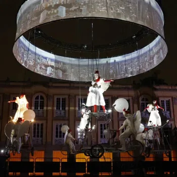 Espectáculo aéreo nocturno con artistas suspendidos y proyección circular